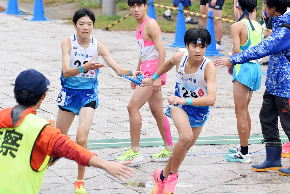 【県中学駅伝男子の部】初優勝した茅ケ崎一。写真は５区三科（左）から６区林のたすきリレー＝横浜八景島・海の公園前周回コース