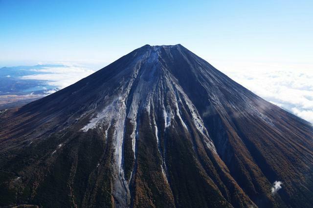 「初冠雪」が観測された富士山。山頂付近から中腹にかけてうっすらと雪が積もっていた=2024年11月7日午前9時37分、朝日新聞社ヘリから、吉田耕一郎撮影