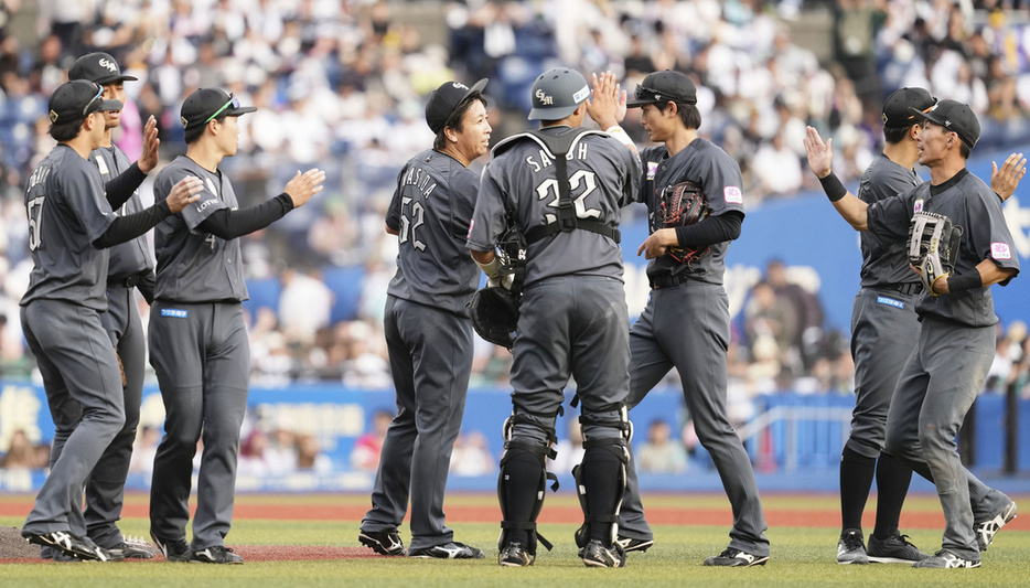 ソフトバンクに勝利しタッチを交わすロッテナイン (C)Kyodo News