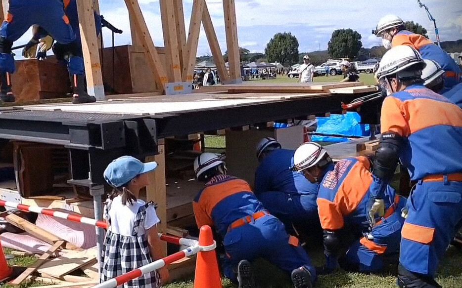 押しつぶされた1階部分をのぞき込み、閉じ込められた人の救助を想定して訓練する消防団員ら＝熊本県菊陽町で2024年10月6日午後2時5分、中里顕撮影