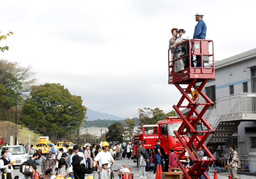 【高所作業車の乗車体験を楽しむ親子＝亀山市布気町の亀山サンシャインパークで】