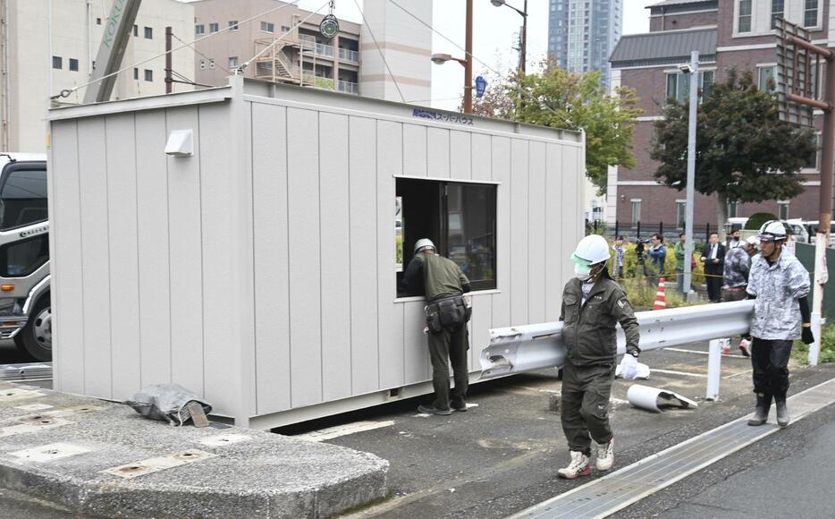 建設予定地で工事の準備作業を始める作業員ら（15日午前、北九州市で）