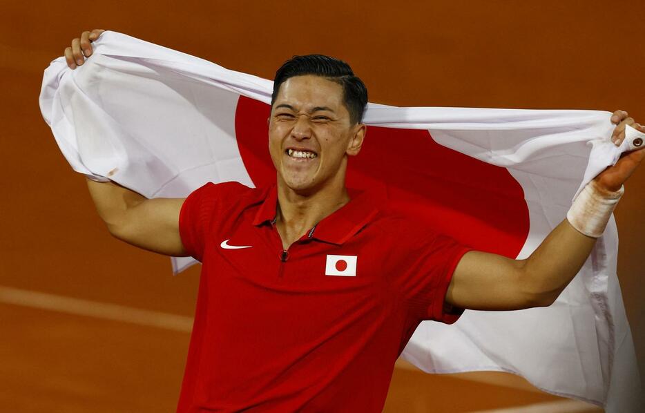 男子シングルス決勝　ヒューエットを破って優勝し、日の丸を掲げて喜ぶ小田凱人（ロイター）