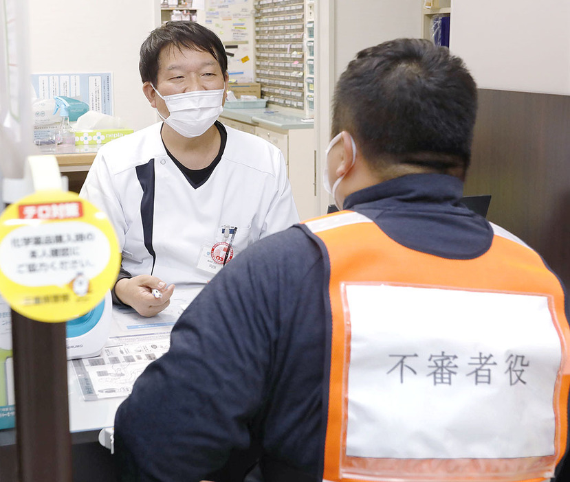 化学薬品を購入しようとする不審者への対応を訓練する局員＝殿町のセンター薬局市民病院前店で