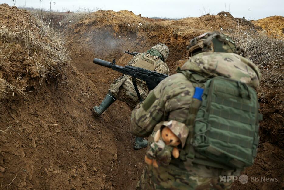 ウクライナ・ドネツク州の前線近くでの訓練中、塹壕から射撃するウクライナ兵（2024年2月23日撮影）。【翻訳編集】 AFPBB News