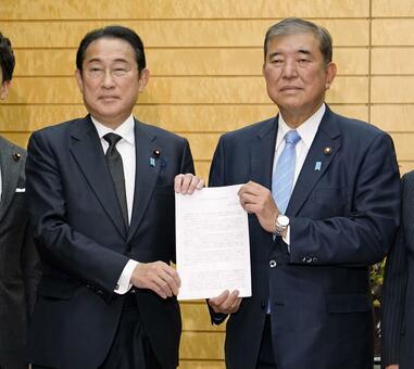 石破首相（右）に自民議員連盟の提言を手渡す岸田前首相（写真：共同通信社）