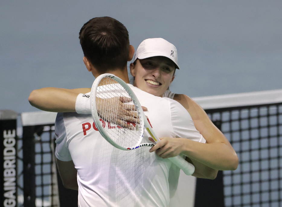 女子テニスの国別対抗戦、ビリー・ジーン・キング・カップ（ＢＪＫ杯）ファイナルズ（決勝大会）は１５日、スペインのマラガで１回戦を行い、ポーランドと英国が準々決勝進出を果たした。写真奥はポーランドのイガ・シフィオンテク（２０２４年　ロイター/Jon Nazca）