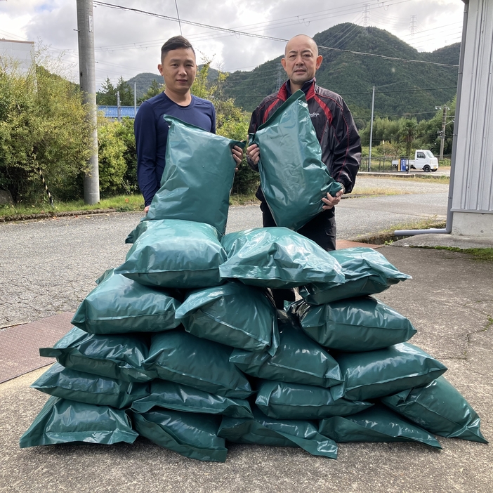 園児服の生産工程で出る端切れを使って開発した土のうをアピールする竹内さん（右）と従業員＝兵庫県丹波市山南町大河で