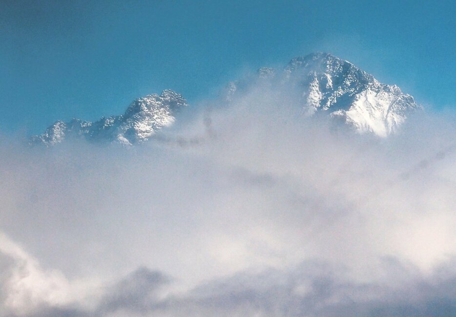 雲の切れ間に姿を現した雪化粧した剱岳＝７日午後２時１６分、上市町法音寺（堀田信一さん撮影）