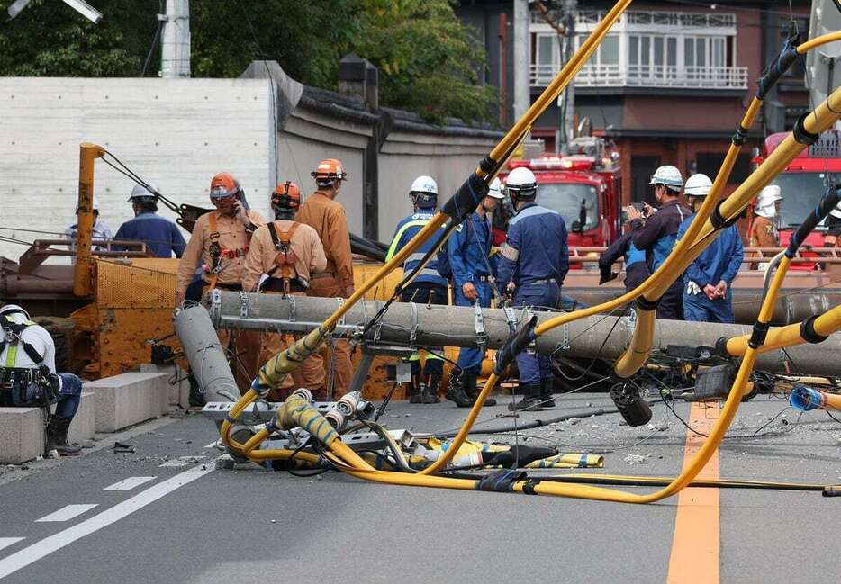 重機が横転し、影響で折れた電柱が歩道を塞いだ＝5日午前11時13分、大阪市都島区（泰道光司撮影）