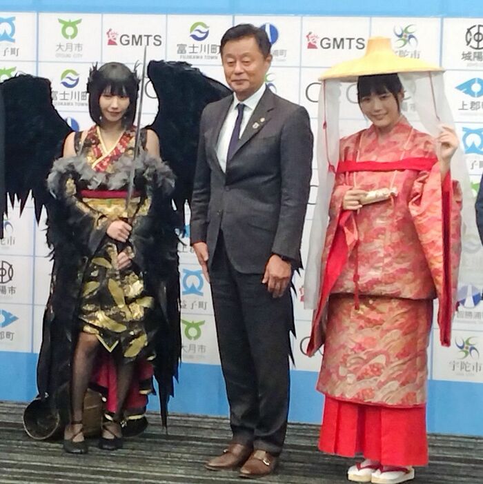 記者発表会に登場したコスプレイヤーのえなこさん（左）と東雲うみさん（右）、那智勝浦町の堀順一郎町長＝東京都で、和歌山県那智勝浦町提供