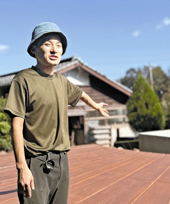 外気浴場のウッドデッキを案内する丸山さん