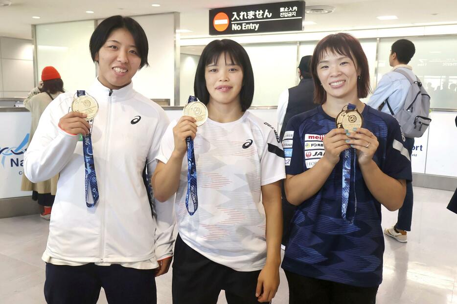 レスリングの非五輪階級の世界選手権から帰国した女子代表の（右から）金城梨紗子、清岡もえ、石井亜海＝1日、成田空港