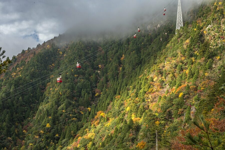 雲の切れ間から光が入り、紅葉のパッチワークのような山肌をより印象的にしてくれます（撮影：杉村航）