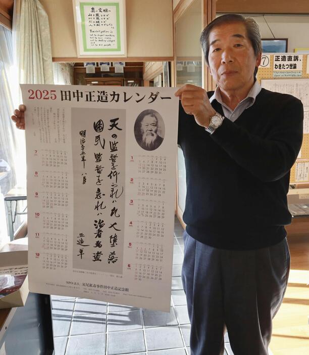 復活販売された田中正造の言葉を記したカレンダーを持つ島野薫さん＝21日、群馬県館林市