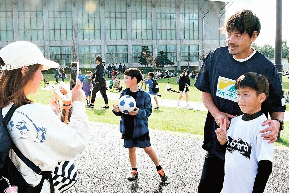 ゴール地点で松井大輔さん（右）と記念撮影する参加者＝出雲市大社町北荒木、島根県立浜山公園