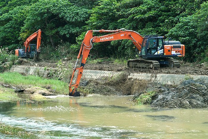 比地川にたまった土砂や流木を取り除く重機＝20日午後3時、国頭村比地