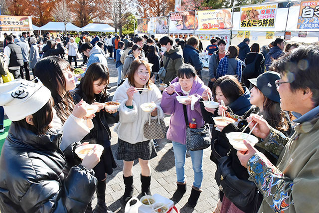 多くの人でにぎわい、熱々を頬張る来場者＝天童市・わくわくランド多目的広場