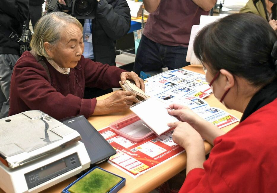 一番乗りで年賀状を購入する石川さん（左）