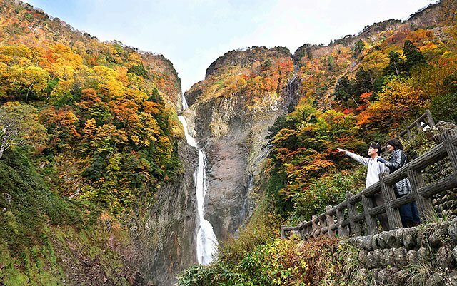 赤や黄色に彩られた称名滝＝立山町芦峅寺