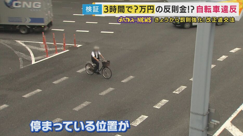 道路の真ん中に自転車を止めて待っている人