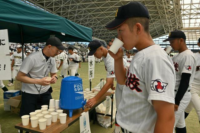 暑さ対策のため屋内で開かれた第106回三重大会の開会式。給水所が設けられ、選手たちが水分補給をした=2024年7月5日、三重県四日市市の四日市ドーム、小林裕子撮影