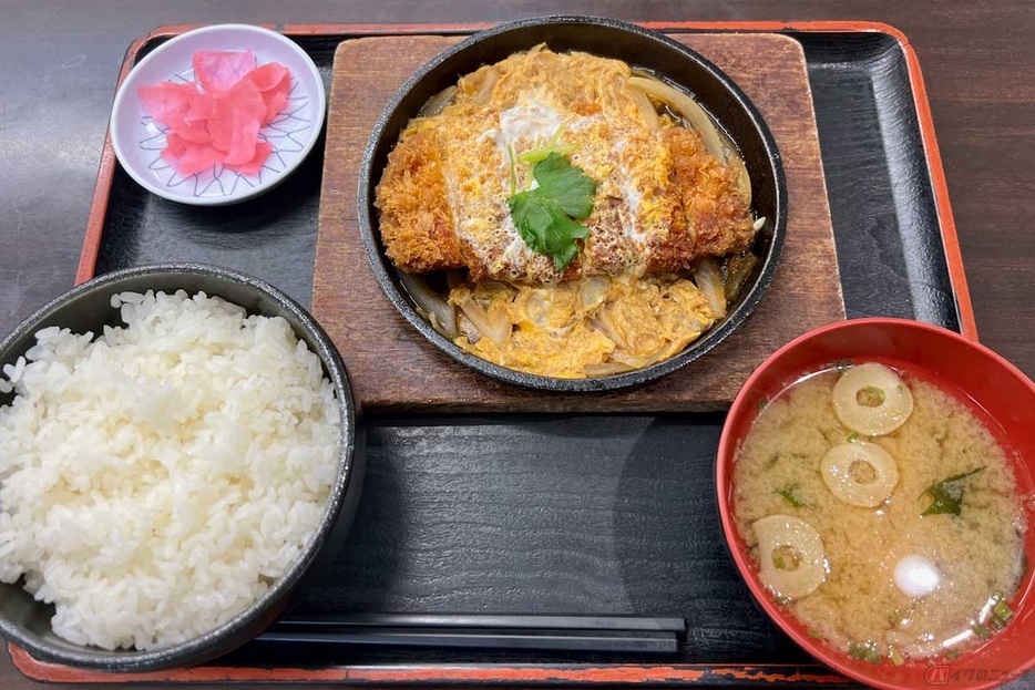 常磐道「美野里PA」（上り）で注文した「かつ鍋定食」（1150円）は、見た目も美しく食欲をそそる。溶き玉子の黄色と桜色の漬物のコントラストも鮮やか