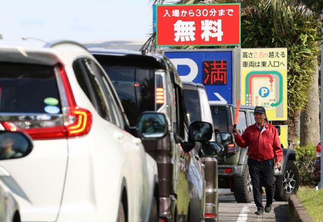 満車になった宮崎市・宮崎空港の駐車場。空きを待つ車の列ができた＝２４日午後