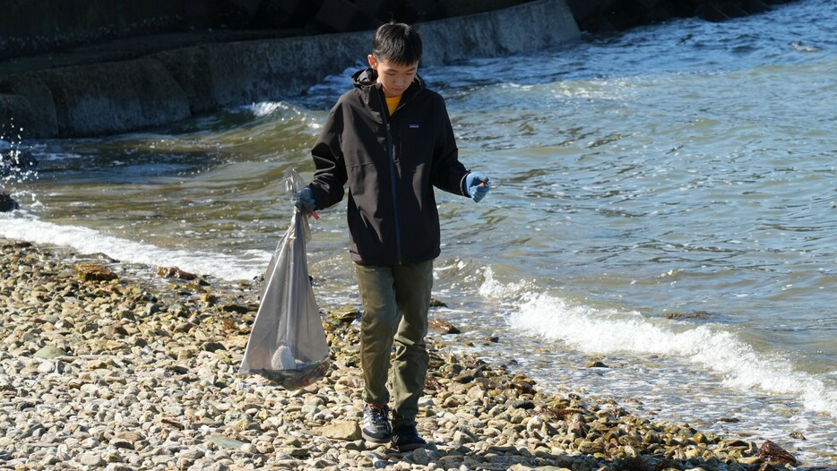 海岸沿いでごみを探す子ども