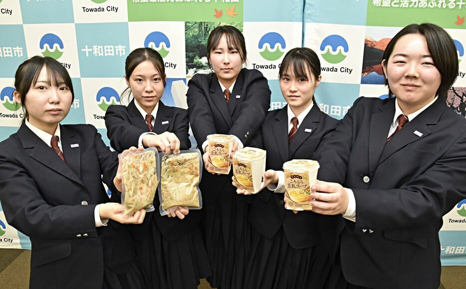 開発したスープを手にする三農恵拓高校家庭クラブの生徒＝5日、十和田市役所