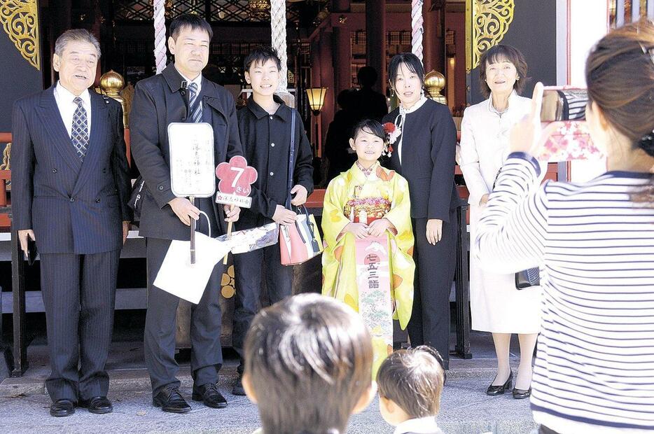 晴れ着姿の子供を囲んで記念撮影する家族連れ（深志神社）