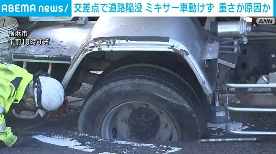 陥没した道路にタイヤがはまったミキサー車