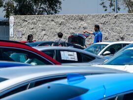 Customers look at vehicles for sale in Fremont, California.