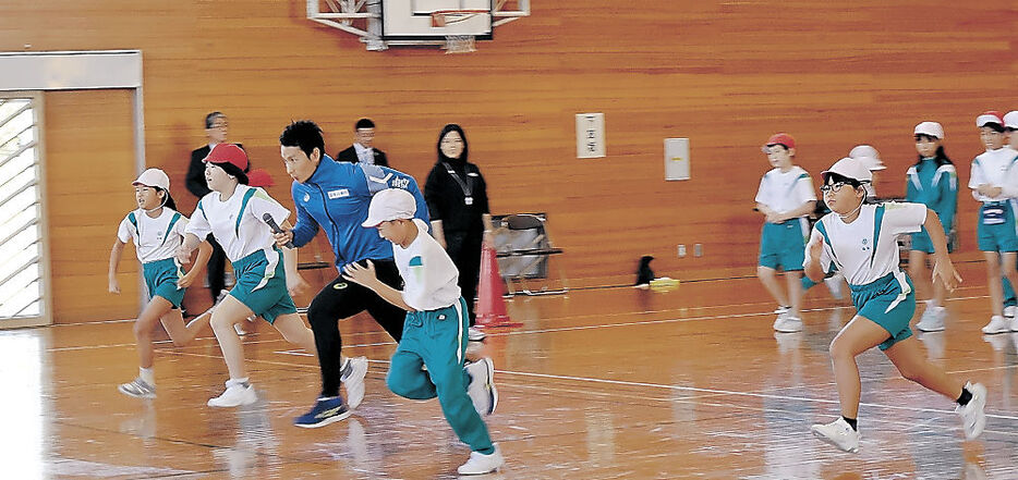 児童と一緒に走る福島選手（手前左から３人目）＝富山市朝日小