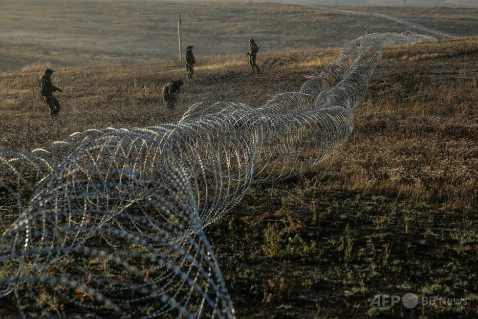 ウクライナ東部ドネツク州の前線に沿って有刺鉄線を設置するウクライナ軍の工兵部隊(2024年10月30日撮影)。【翻訳編集】 AFPBB News