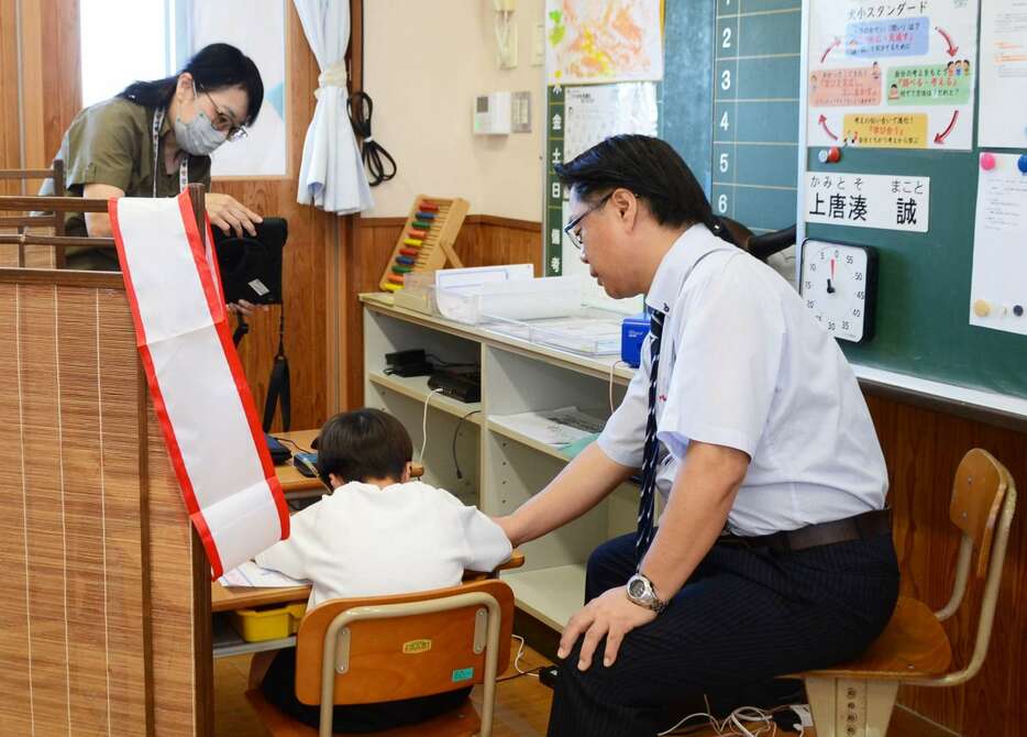 特別支援学級の授業を参観する離島特別支援教育コーディネーターの林和美教諭（左）＝伊仙町の犬田布小学校