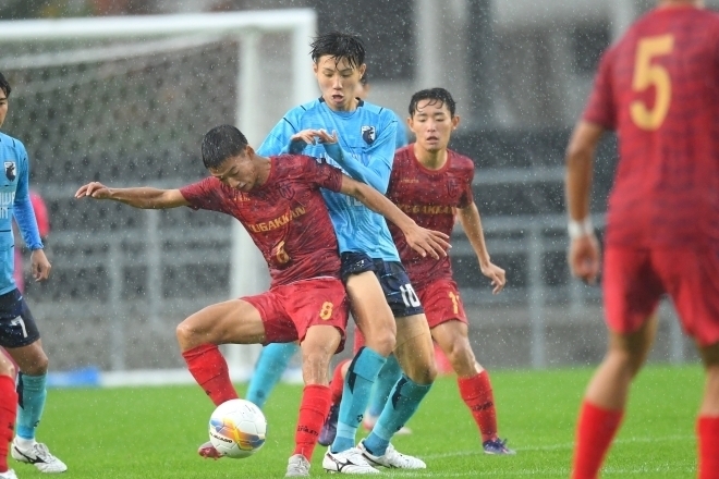 豪雨に見舞われた石川決勝。金沢学院大附（水色）が遊学館（赤）に１－０で競り勝った。写真：鈴木颯太朗