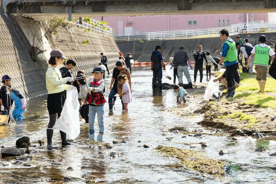 市民らが浅川に入って意欲的にごみ拾いを行う様子。小さなごみから大きなごみまで、さまざまなごみが集まった（写真＝主催者提供）