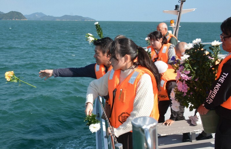 現場海域で犠牲者に花を手向けて冥福を祈る遺族ら＝愛媛県今治市の伯方島沖で2024年11月3日午前11時59分、松倉展人撮影