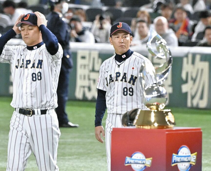 優勝トロフィーを横目に表彰式に向かう井端監督（８９）