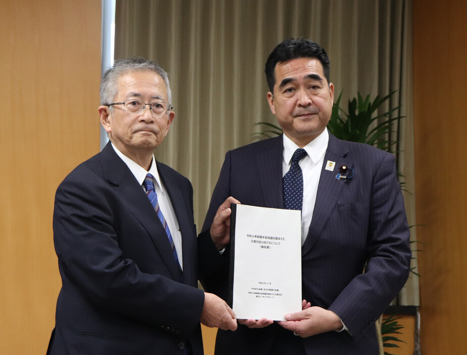 能登半島地震を教訓に災害対応の在り方を検討してきた作業部会の福和伸夫主査（左）から報告書を受け取る坂井学防災担当相＝２６日午後、東京都千代田区