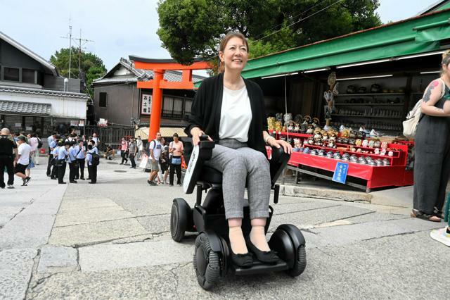 伏見稲荷大社の参道をウィルで進む中村敦美さん=2024年9月27日午前10時53分、京都市伏見区、日比野容子撮影