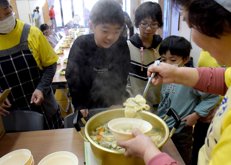 出来上がったすいとんに笑顔を見せる子どもたち