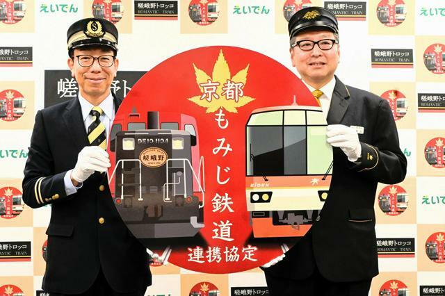 「京都もみじ鉄道」のヘッドマークを持つ三戸尉行・嵯峨野観光鉄道社長（左）と豊田秀明・叡山電鉄社長=2024年10月17日午後2時39分、京都市下京区、日比野容子撮影