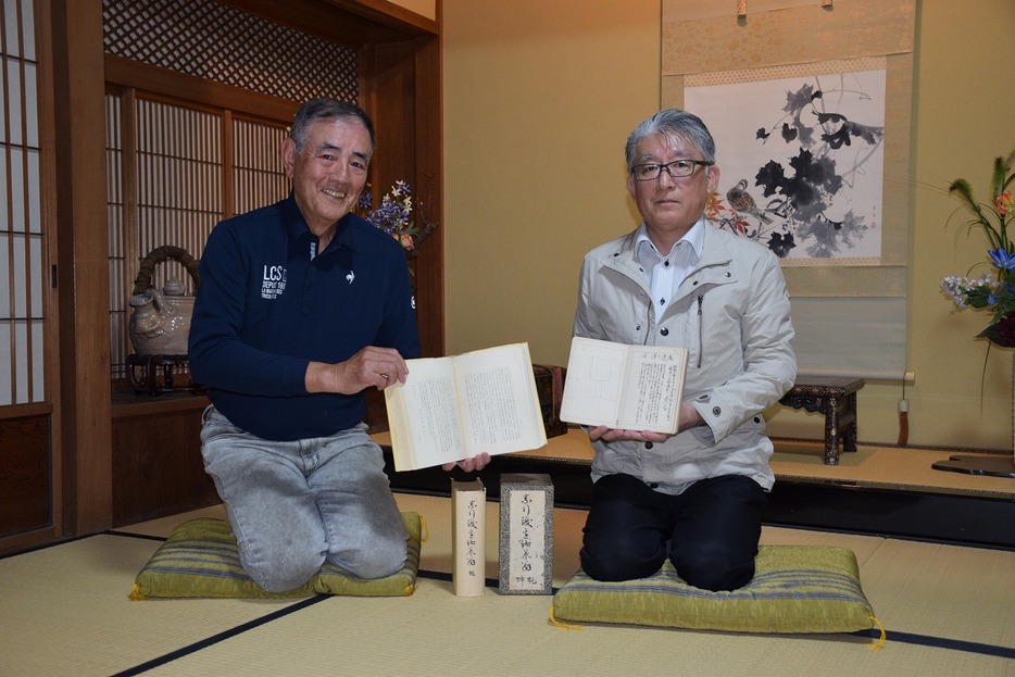 手帳を手にする高良さん（右）と祐策の伝記を持つ渡邊さん（島2丁目の松巌園で）