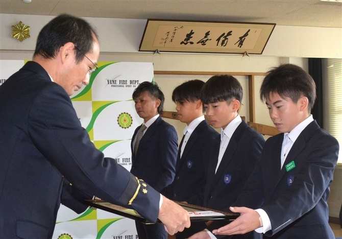 引き締まった表情で水難救助の感謝状を受け取る中学生たち