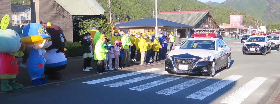 出発するパトカーを見送る参加者たち＝大台町佐原の町役場駐車場で