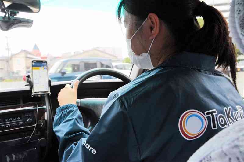 熊本県内でもスタートした日本版ライドシェア。車両を運転するのは一般ドライバーで、スマートフォンの配車アプリを使う＝15日、熊本市中央区