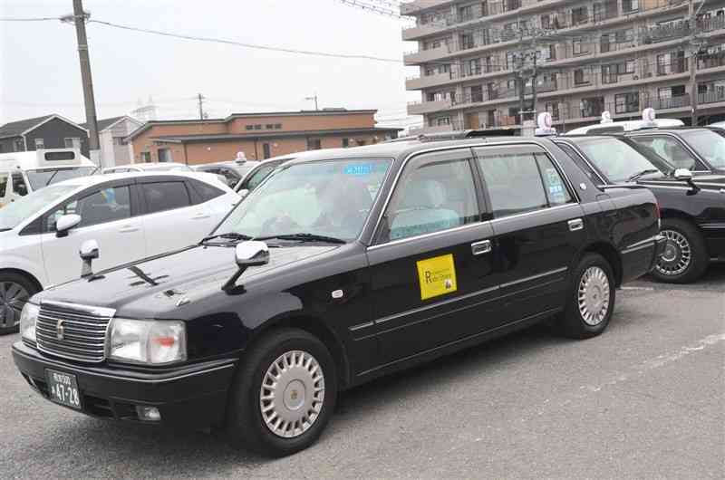 熊本県内でも運行を始めた日本版ライドシェアの車両。タクシーと見分けがつくよう、前方と側面にライドシェアの表示をしている＝15日、熊本市中央区