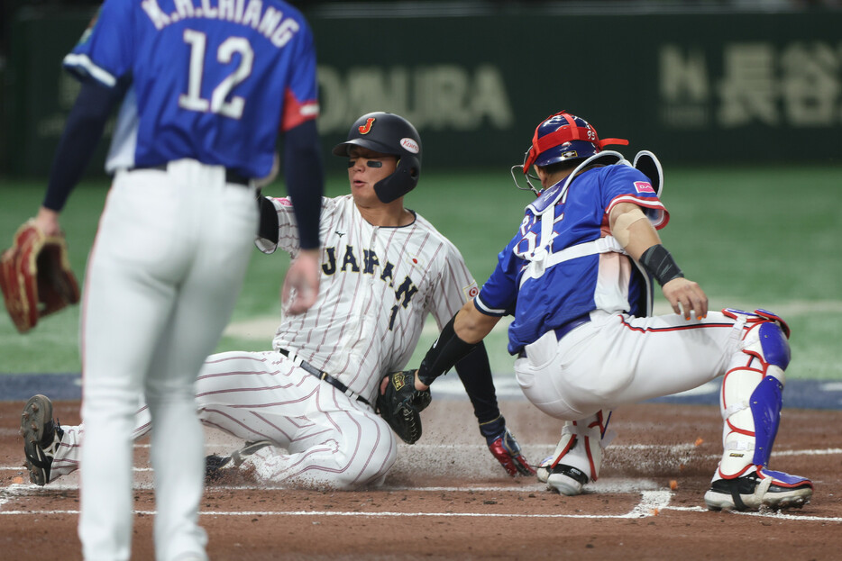 台湾戦の１回、紅林の犠飛で生還した日本代表の三塁走者・森下（中央）＝２３日、東京ドーム